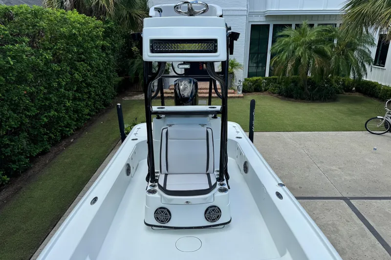 Slide: The Image of 2020 Yellowfin 24 Bay CE boat with seating and console, parked in a driveway. - 13