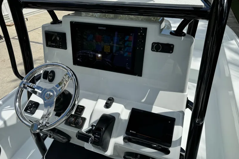 Slide: The Image of 2020 Yellowfin 24 Bay CE boat dashboard with steering wheel and electronic controls. - 19