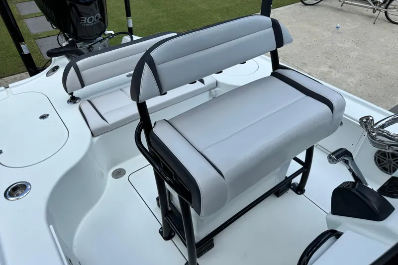 Slide: The Image of 2020 Yellowfin 24 Bay CE boat interior with cushioned seating and 300 horsepower engine. - 20
