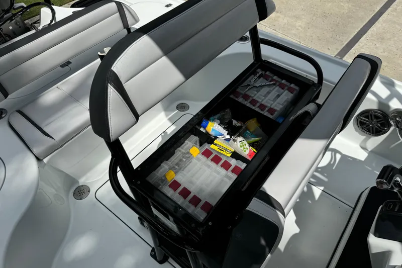 Slide: The Image of 2020 Yellowfin 24 Bay CE boat interior with storage compartment open, revealing fishing gear. - 22