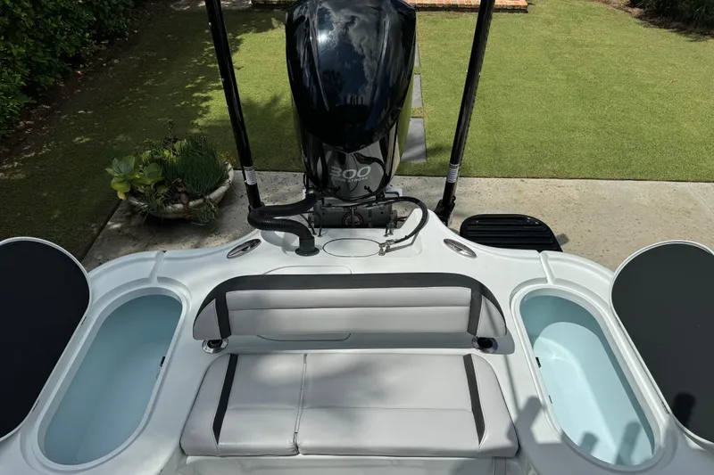 Slide: The Image of 2020 Yellowfin 24 Bay CE boat with seating and outboard motor, docked on grass. - 24