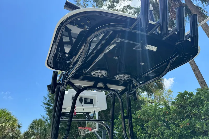 Slide: The Image of 2020 Yellowfin 24 Bay CE boat's T-top with rod holders and speakers, under clear blue sky. - 27