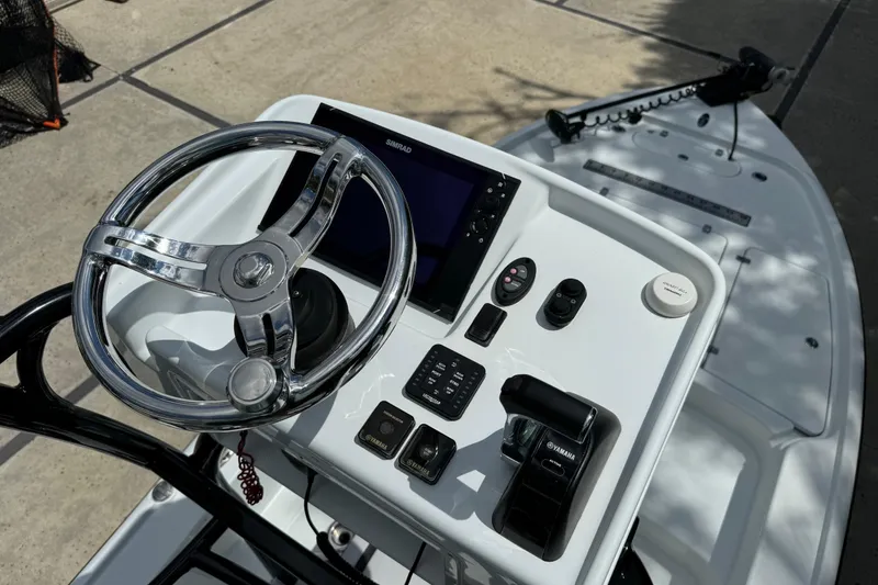 Slide: The Image of 2020 Yellowfin 24 Bay CE boat console with steering wheel and navigation controls. - 30