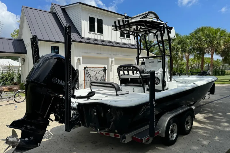 Slide: The Image of 2020 Yellowfin 24 Bay CE boat on trailer, parked near a modern house. - 5