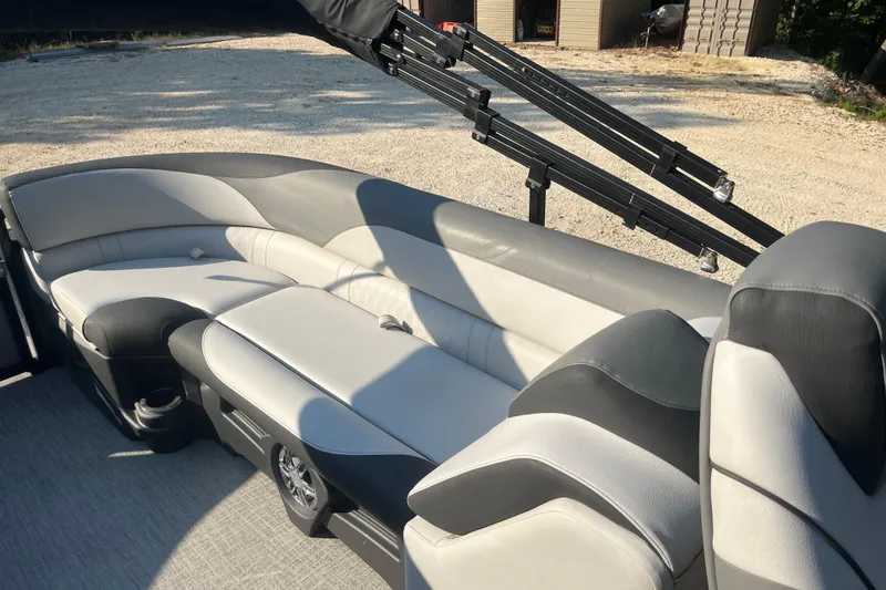 Slide: The Image of 2023 Avalon LSZ 2585 QL boat interior with gray and white seating, outdoor setting. - 9