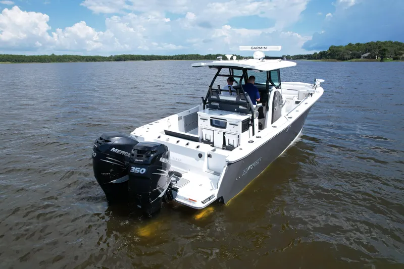 Slide: The Image of 2021 Blackfin 332 CC boat with dual Mercury 350 engines on a calm lake. - 12