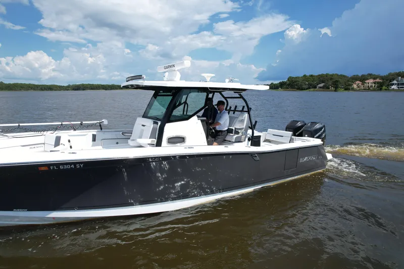 Slide: The Image of 2021 Blackfin 332 CC boat cruising on a lake under a partly cloudy sky. - 15