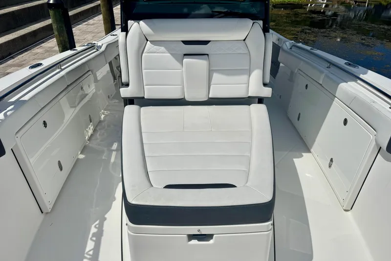 Slide: The Image of 2021 Blackfin 332 CC boat interior with white cushioned seating and storage compartments. - 30