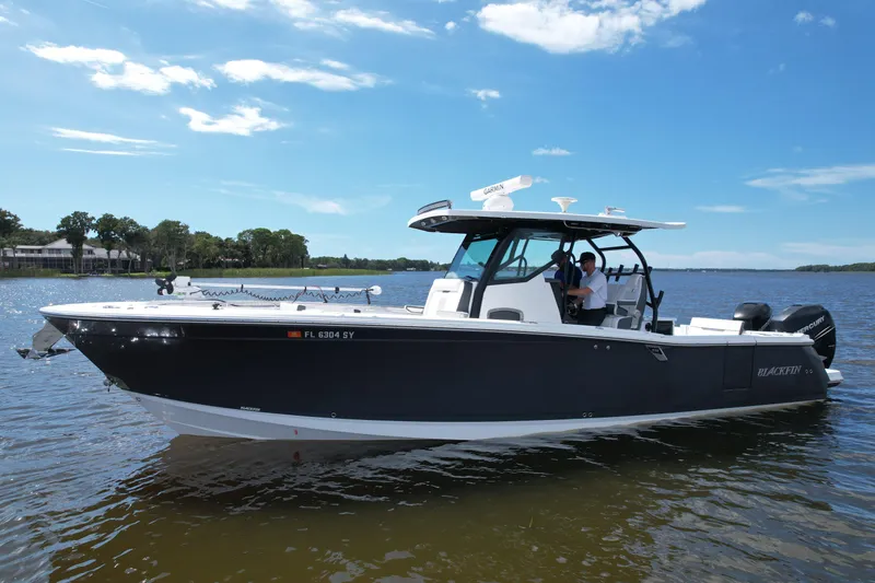 Slide: The Image of 2021 Blackfin 332 CC boat on calm water under a clear blue sky. - 4