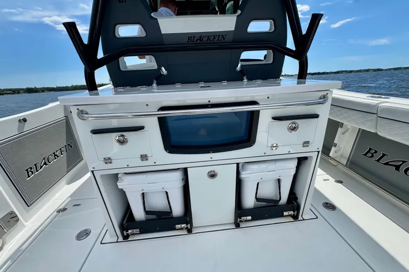 Slide: The Image of 2021 Blackfin 332 CC boat interior with storage compartments and seating, on the water. - 48