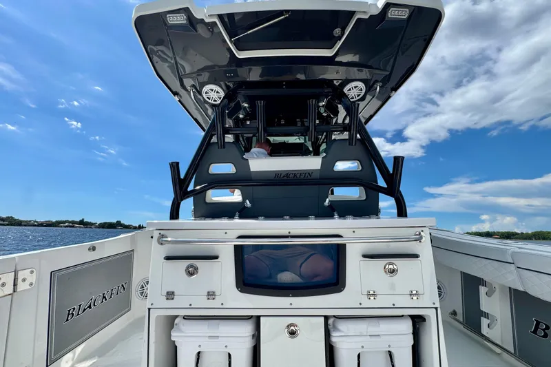 Slide: The Image of 2021 Blackfin 332 CC boat interior with storage and seating, under a clear blue sky. - 58
