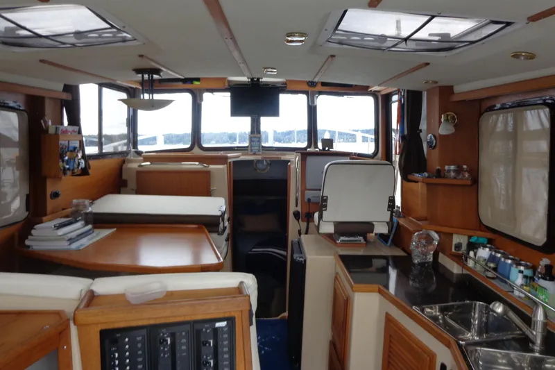Slide: The Image of Interior of 2011 Ranger Tugs R-29 Classic boat, featuring kitchen and seating area. - 12