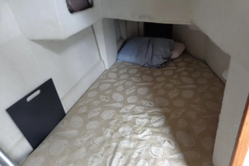 Slide: The Image of Cozy cabin interior of 2011 Ranger Tugs R-29 Classic, featuring a patterned bed and pillow. - 16