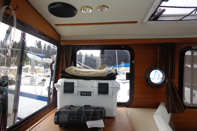 Slide: The Image of Interior of 2011 Ranger Tugs R-29 Classic, featuring a Yeti cooler and scenic marina view. - 18