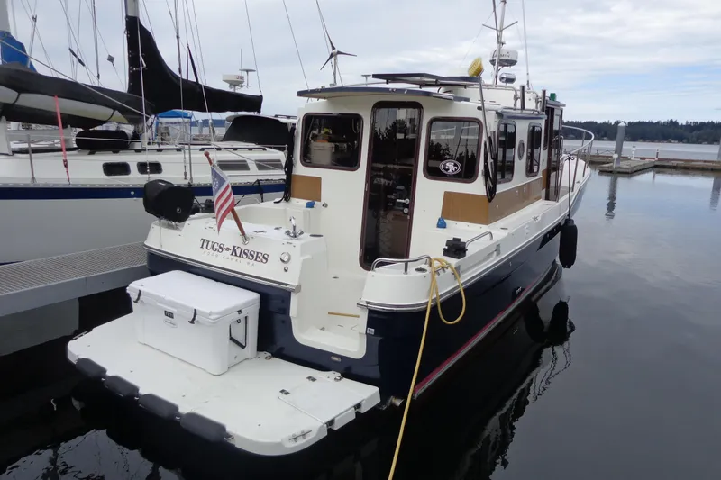 Slide: The Image of 2011 Ranger Tugs R-29 Classic boat docked, featuring a sleek design and trailer. - 2