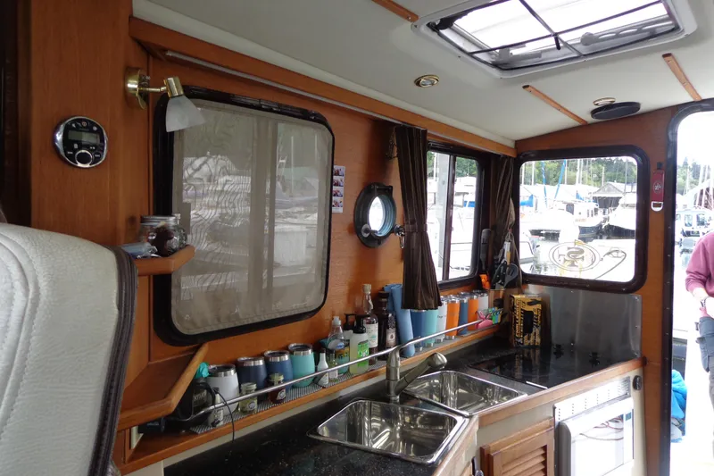 Slide: The Image of Interior of 2011 Ranger Tugs R-29 Classic, featuring kitchen area with sink and windows. - 21