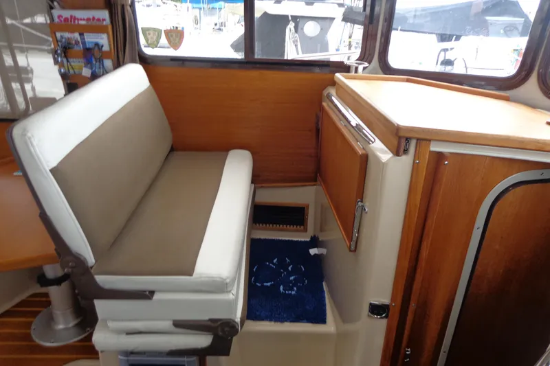 Slide: The Image of Interior of 2011 Ranger Tugs R-29 Classic, featuring seating and wooden cabinetry. - 23