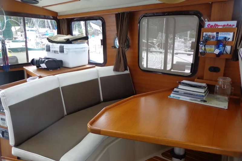 Slide: The Image of Interior of 2011 Ranger Tugs R-29 Classic, featuring a cozy dining area with a table. - 24