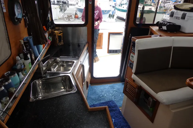 Slide: The Image of Interior of 2011 Ranger Tugs R-29 Classic, featuring kitchen and seating area. - 26