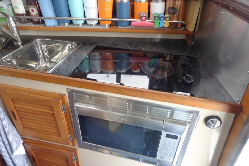 Slide: The Image of Compact kitchen in 2011 Ranger Tugs R-29 Classic, featuring sink, stove, and microwave. - 27