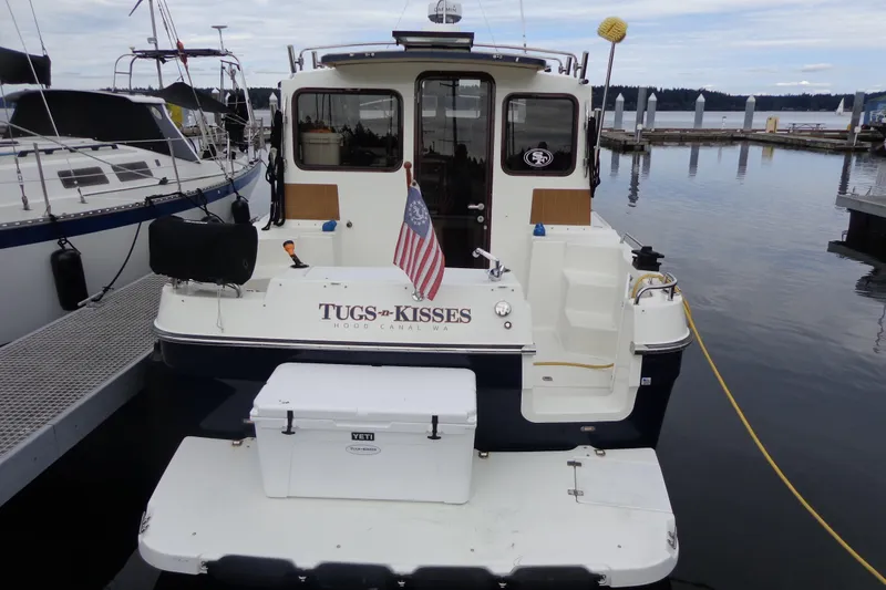 Slide: The Image of 2011 Ranger Tugs R-29 Classic boat docked, rear view with American flag and cooler. - 3