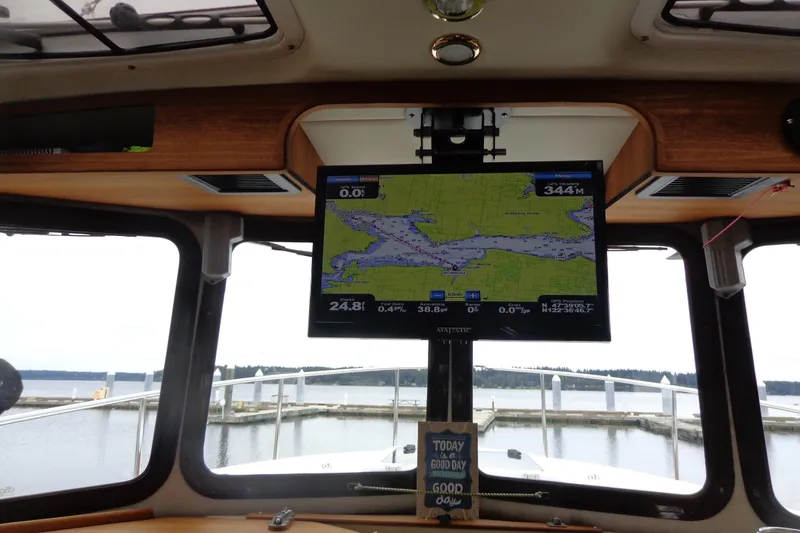 Slide: The Image of Interior view of 2011 Ranger Tugs R-29 Classic, featuring navigation screen and marina backdrop. - 32