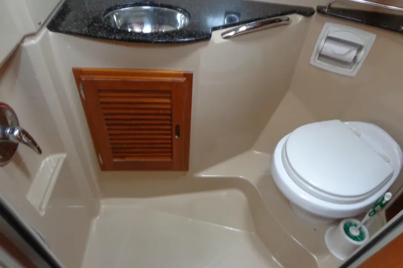 Slide: The Image of 2011 Ranger Tugs R-29 Classic bathroom with sink, toilet, and wooden cabinet. - 38