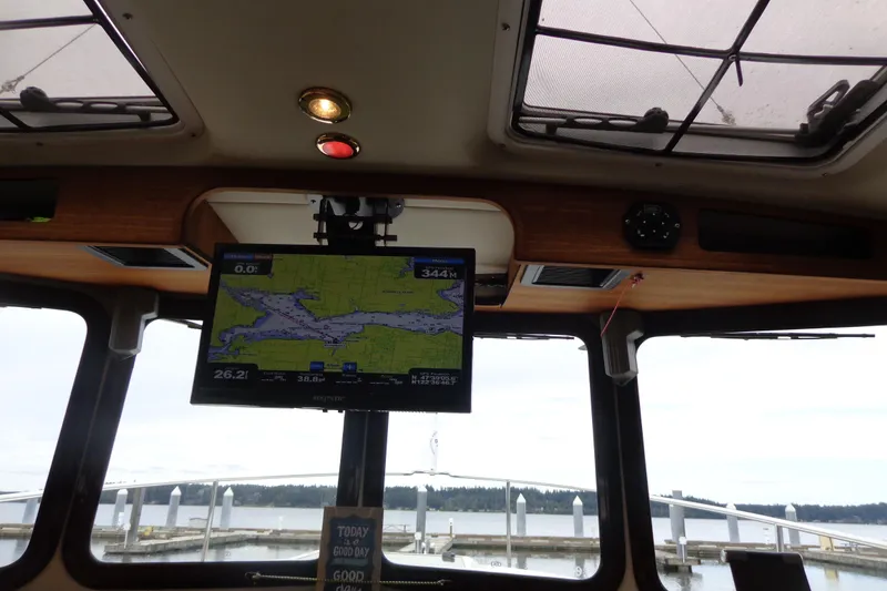 Slide: The Image of Interior view of 2011 Ranger Tugs R-29 Classic, featuring navigation screen and marina backdrop. - 43