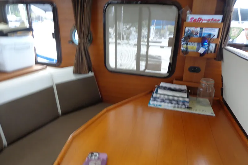 Slide: The Image of Interior of 2011 Ranger Tugs R-29 Classic, featuring a cozy seating area and wooden table. - 44