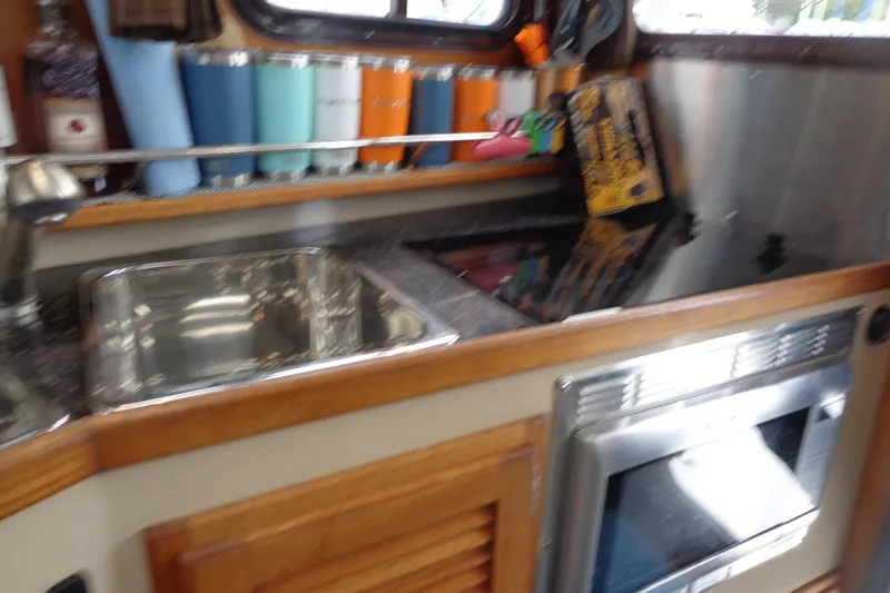 Slide: The Image of 2011 Ranger Tugs R-29 Classic interior kitchen with sink, stove, and storage. - 45