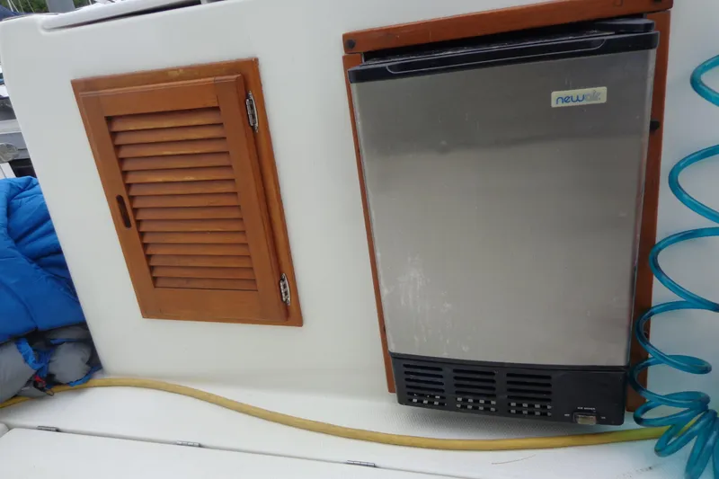 Slide: The Image of 2011 Ranger Tugs R-29 Classic interior with fridge and wooden cabinet. - 55