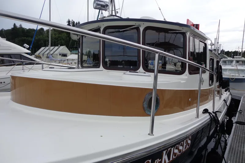 Slide: The Image of 2011 Ranger Tugs R-29 Classic boat docked, featuring sleek design and polished railings. - 6
