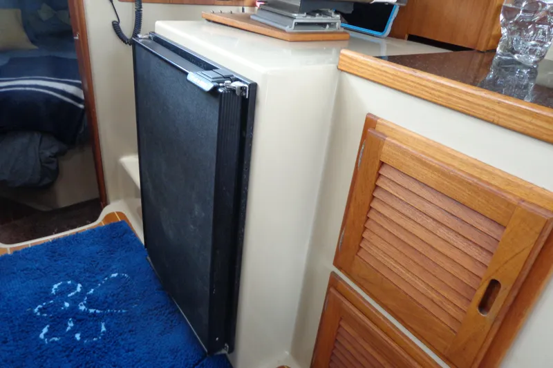 Slide: The Image of Interior of 2011 Ranger Tugs R-29 Classic, featuring compact kitchen area with wooden cabinetry. - 60