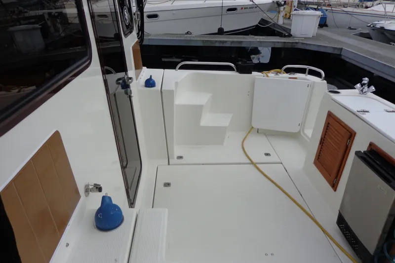 Slide: The Image of 2011 Ranger Tugs R-29 Classic boat deck with trailer, featuring clean white surfaces. - 9