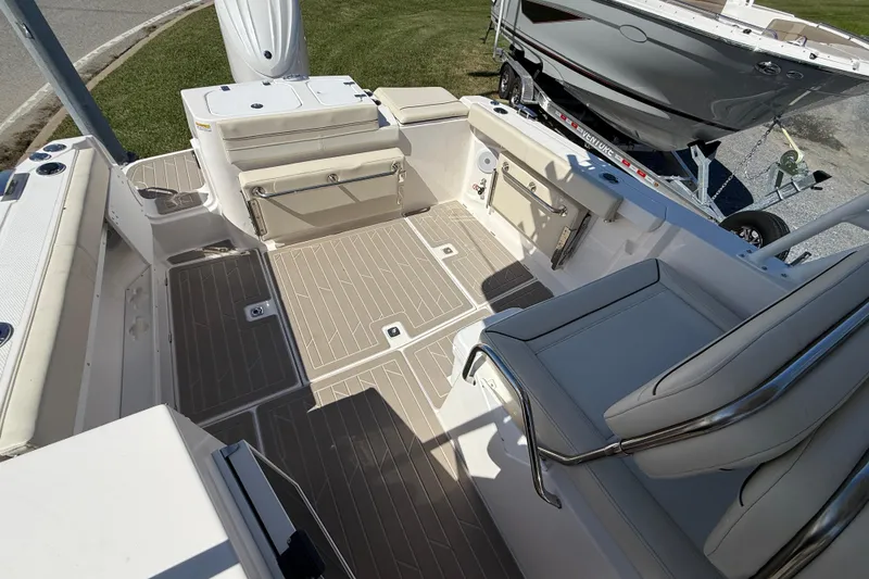 Slide: The Image of 2026 Solara S-250 DC boat interior with beige seating and deck, parked on grass. - 5