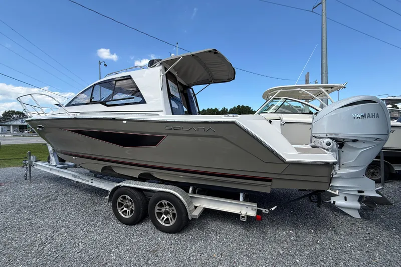 The Image of 2026 Solara S-250 C boat on trailer with Yamaha outboard motor, parked outdoors. - 1