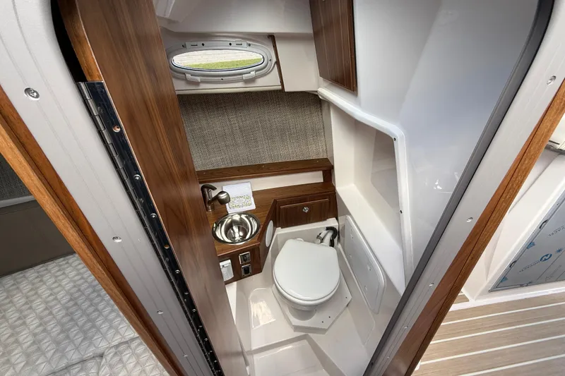 Slide: The Image of Compact bathroom in 2026 Solara S-250 C boat with wood accents and stainless steel sink. - 10