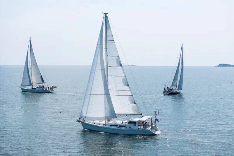 The Image of Sailboats on open water, featuring a 2024 Outbound 46 model. - 0