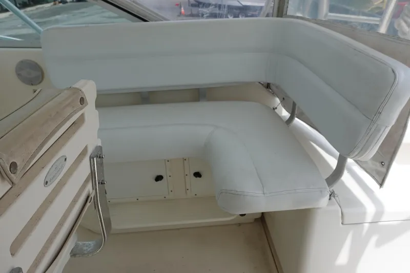 Slide: The Image of 1997 Pursuit 3400 Offshore boat interior with white cushioned seating. - 15