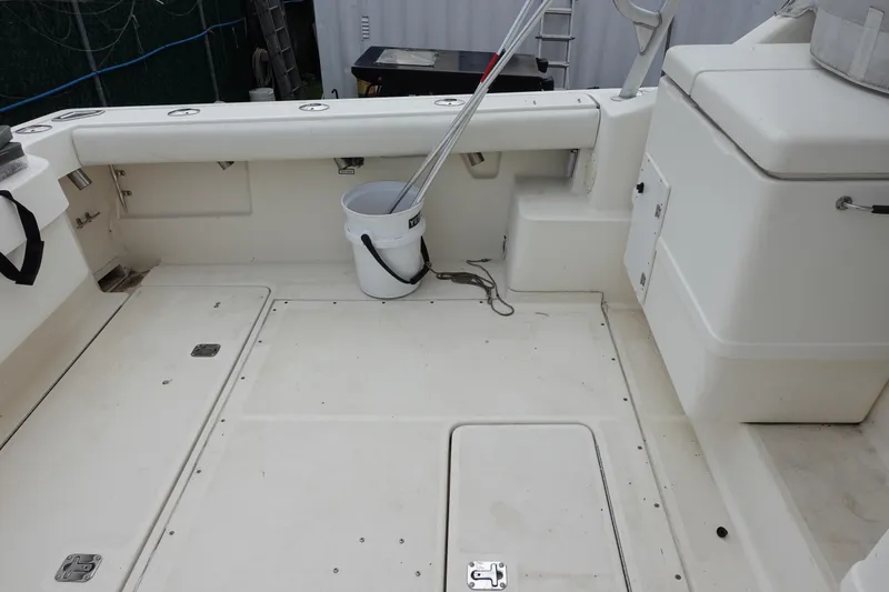 Slide: The Image of 1997 Pursuit 3400 Offshore boat deck with bucket and fishing gear. - 21