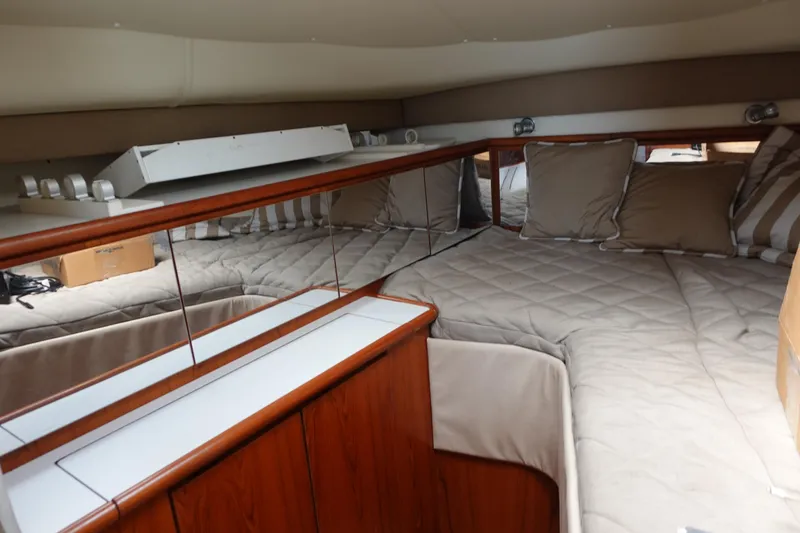 Slide: The Image of Interior cabin of a 1997 Pursuit 3400 Offshore boat with cozy bedding and wood accents. - 26