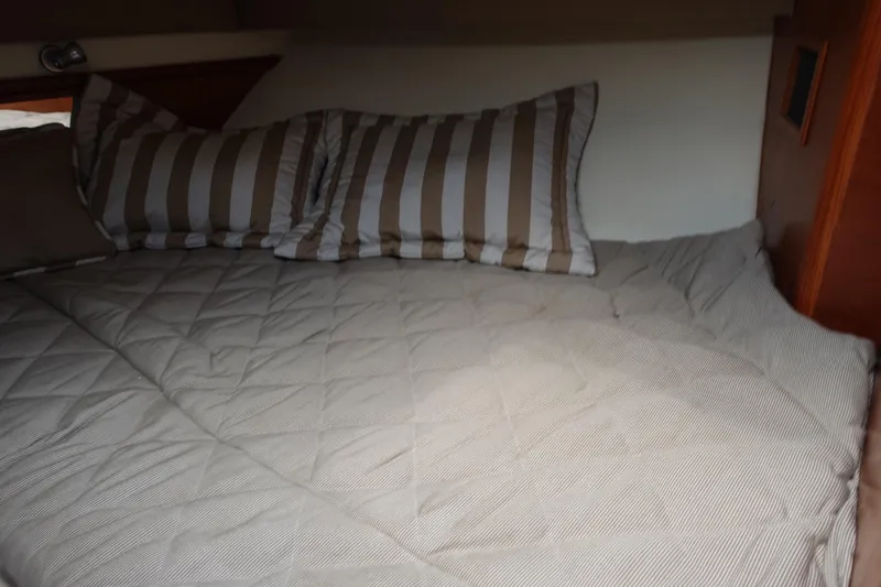 Slide: The Image of Cozy cabin bed with striped pillows in 1997 Pursuit 3400 Offshore boat. - 28