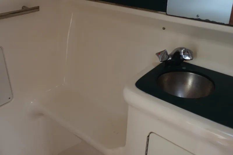 Slide: The Image of Interior of 1997 Pursuit 3400 Offshore boat with sink and seating area. - 31