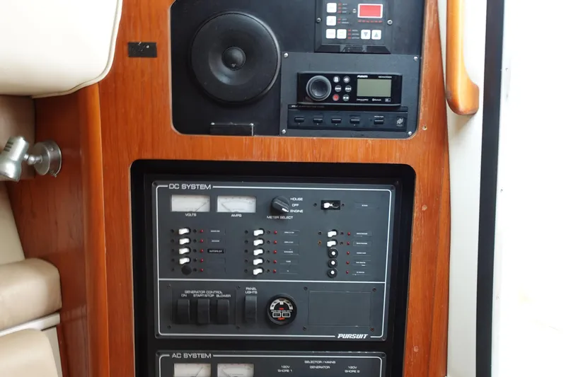 Slide: The Image of Control panel of a 1997 Pursuit 3400 Offshore boat, featuring DC and AC systems. - 33