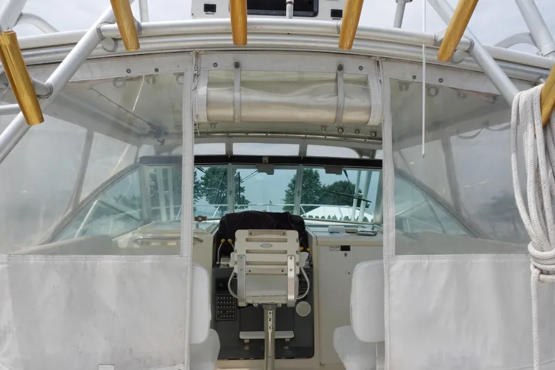 Slide: The Image of 1997 Pursuit 3400 Offshore boat cockpit with clear enclosure and helm station. - 6