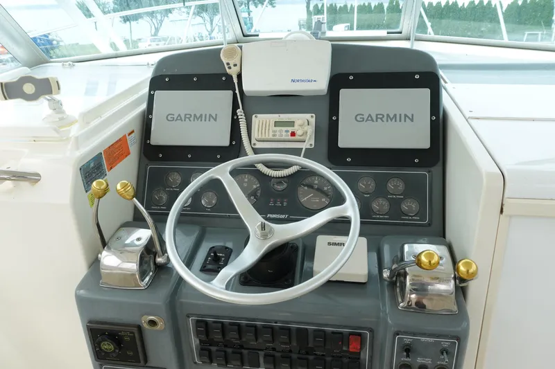 Slide: The Image of Cockpit of 1997 Pursuit 3400 Offshore boat with Garmin navigation system and steering wheel. - 9