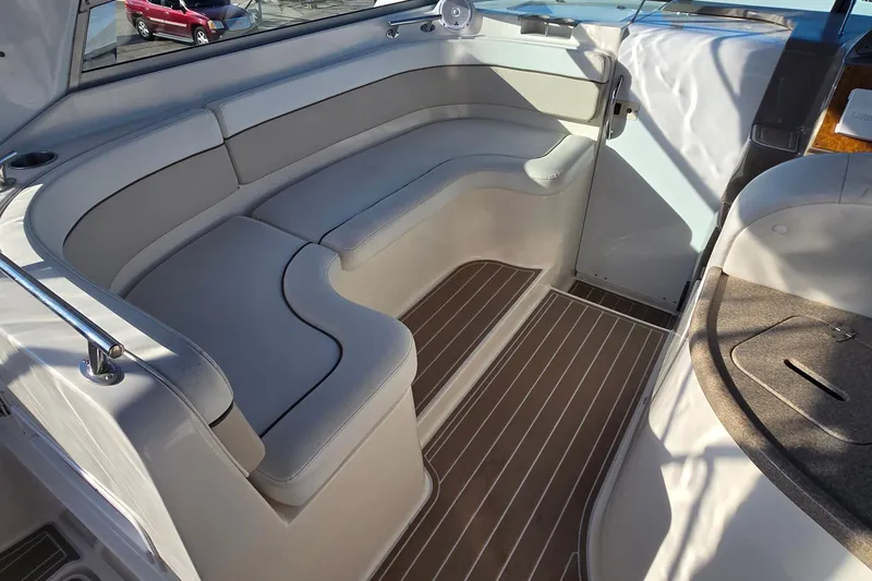 Slide: The Image of 2007 Rinker 320 Express Cruiser interior with white seating and wood-patterned flooring. - 12