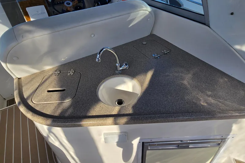 Slide: The Image of 2007 Rinker 320 Express Cruiser kitchenette with sink and countertop. - 14