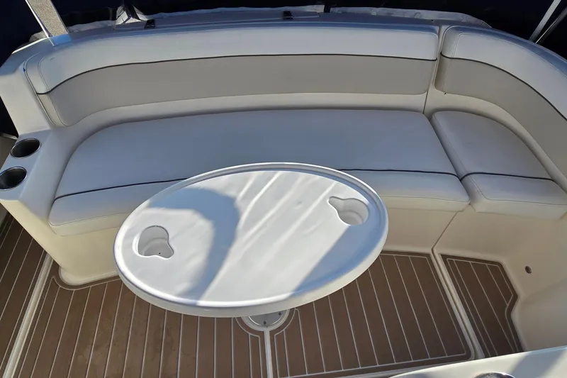 Slide: The Image of 2007 Rinker 320 Express Cruiser interior with cushioned seating and oval table. - 19