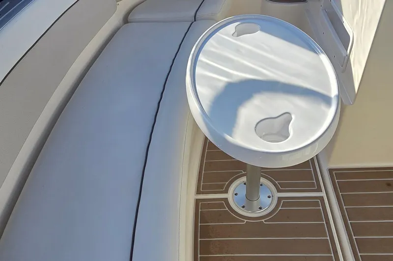 Slide: The Image of 2007 Rinker 320 Express Cruiser interior with seating and round table on deck. - 20